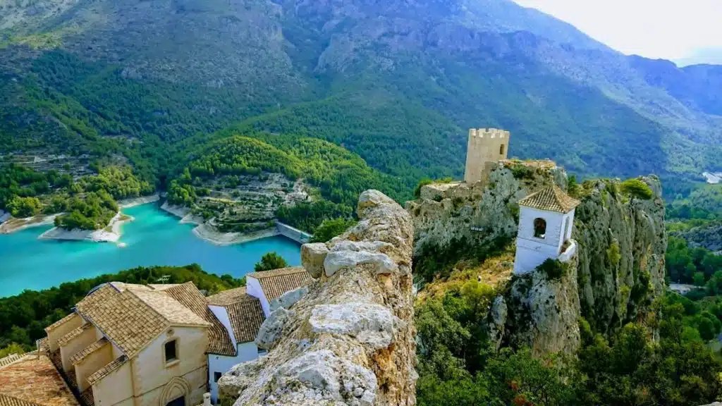 Guadalest castle and village perched on a rocky outcrop above a turquoise reservoir